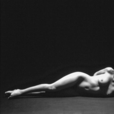 Nu féminin allongé, éclairage sombre et contrasté.