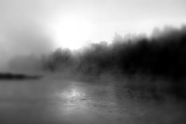 # Fog Une scène brumeuse au bord de l'eau avec un léger reflet lumineux.